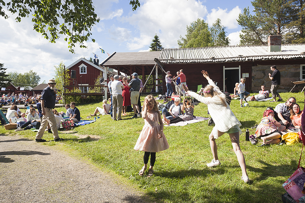 Gammelstad kyrkstads logotyp, ett G med en bild av kyrkstugor bakom